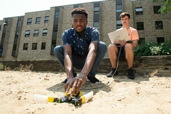 Notre Dame electrical engineering Ph.D. student Nnamdi Chikere and undergraduate John Simon McElroy, a Naughton Fellow from University College Dublin, with a robotic sea turtle.