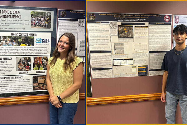 A woman in a yellow top and a man in a navy shirt stand by Notre Dame research posters.